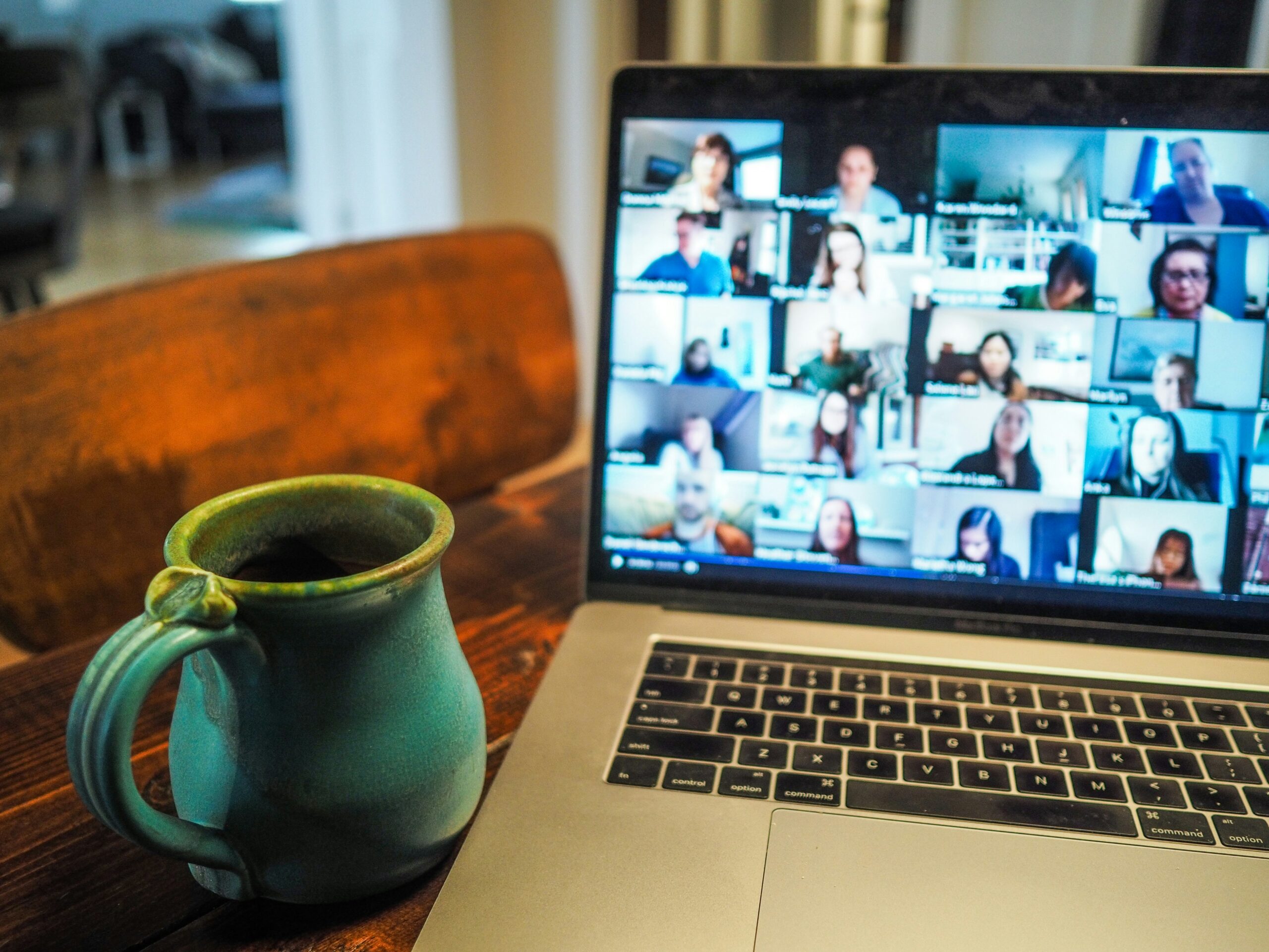 Laptop showing webinar with coffee cup next to the laptop